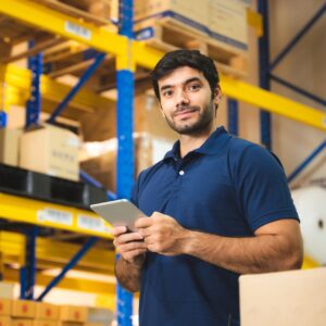 Person holding a tablet while standing in a warehouse